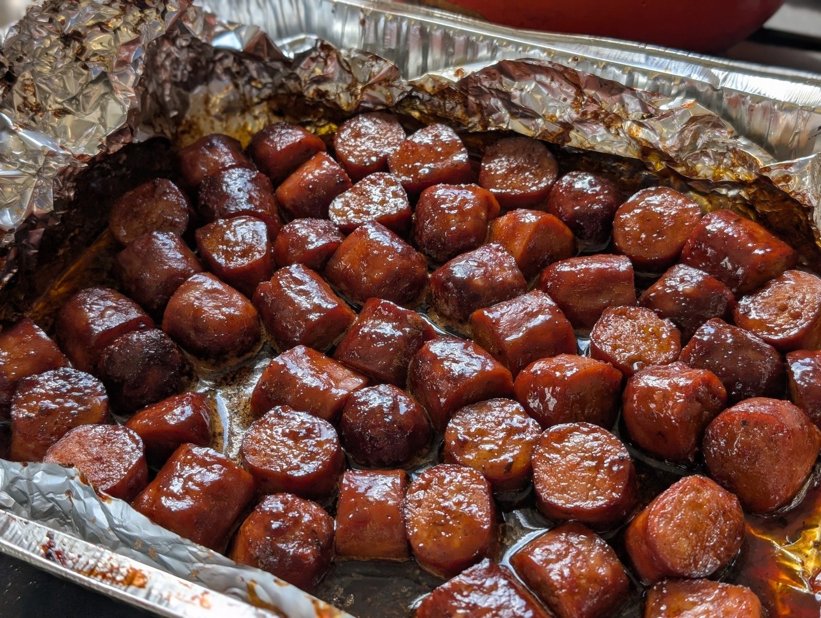 Glazed, lacquered sausages glistening off the grill