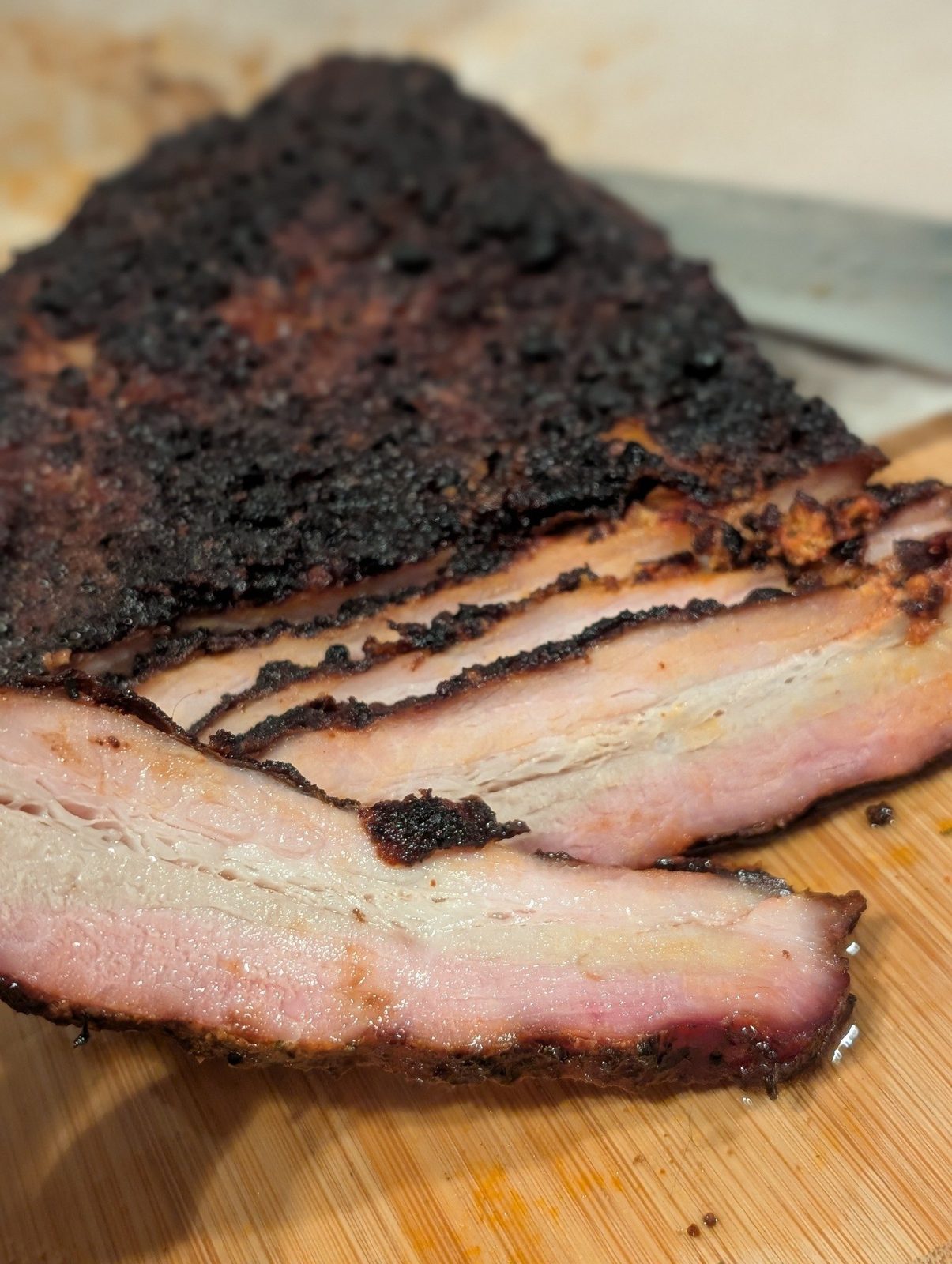 A close-up of sliced meat showing bark, fat and a smoke ring