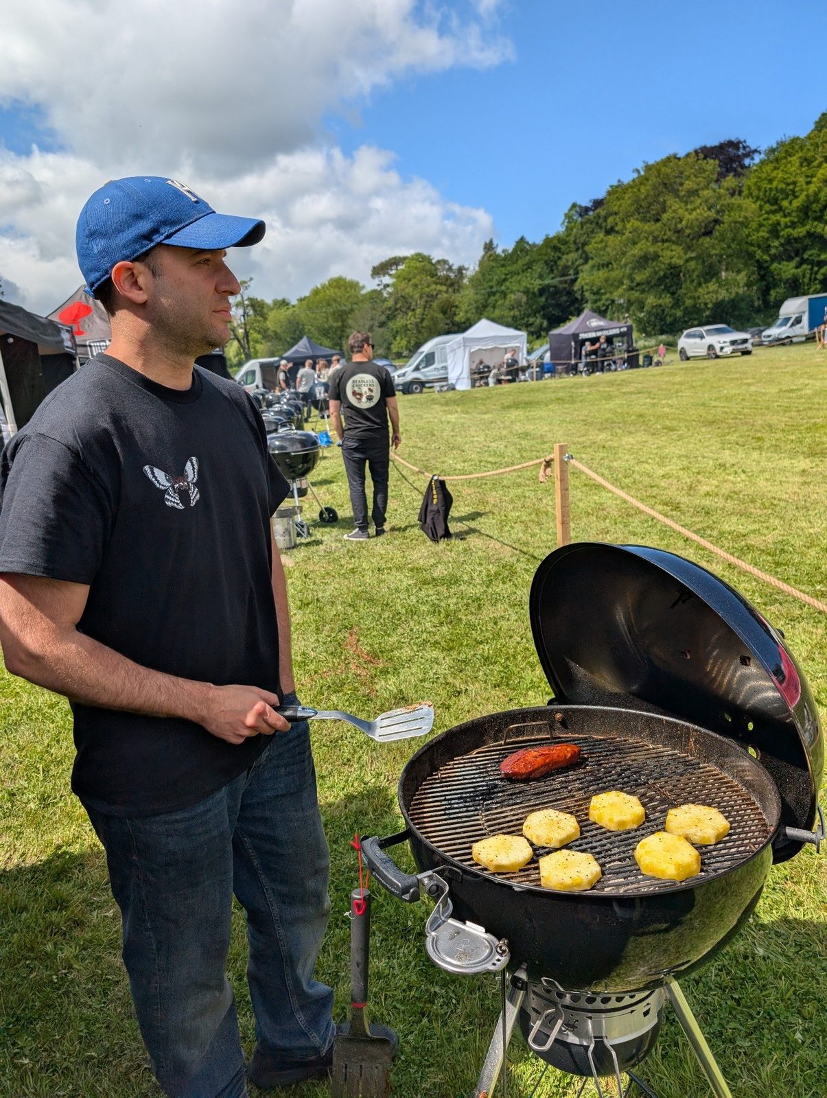 Jared tending a grill with pineapple slices during a competition