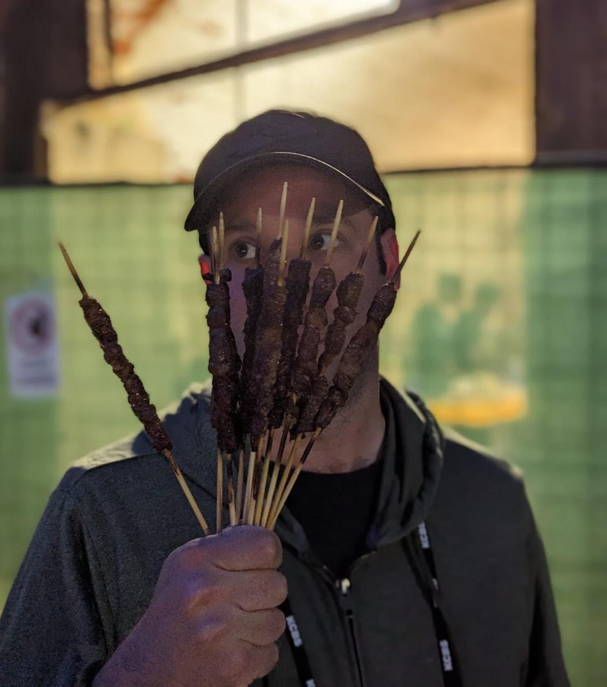Jared holding a bundle of grilled skewers
